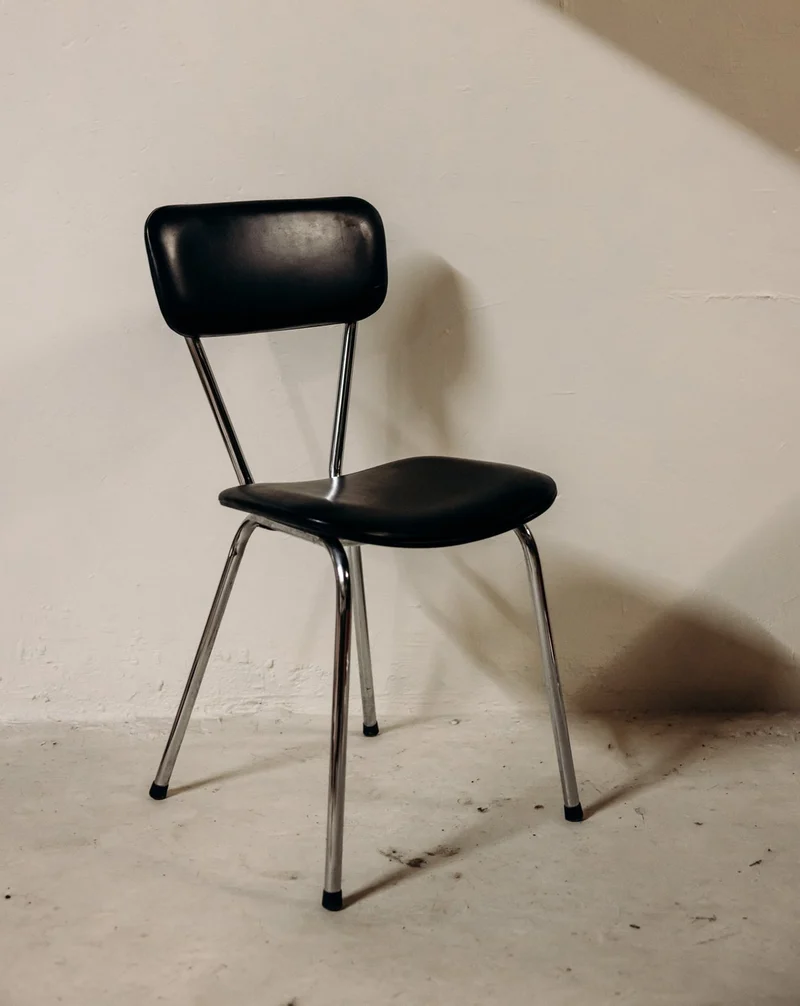 Alma, la chaise en simili cuir noir au cadre chromé N°1971