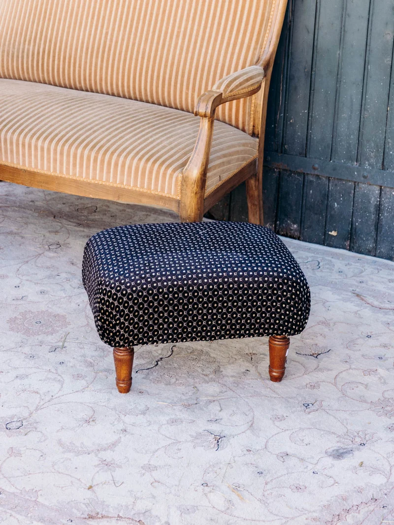 Jean-Philippe, le pouf retapissé en tissu noir à motifs N°100