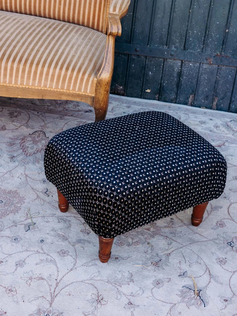 Jean-Philippe, le pouf retapissé en tissu noir à motifs N°100