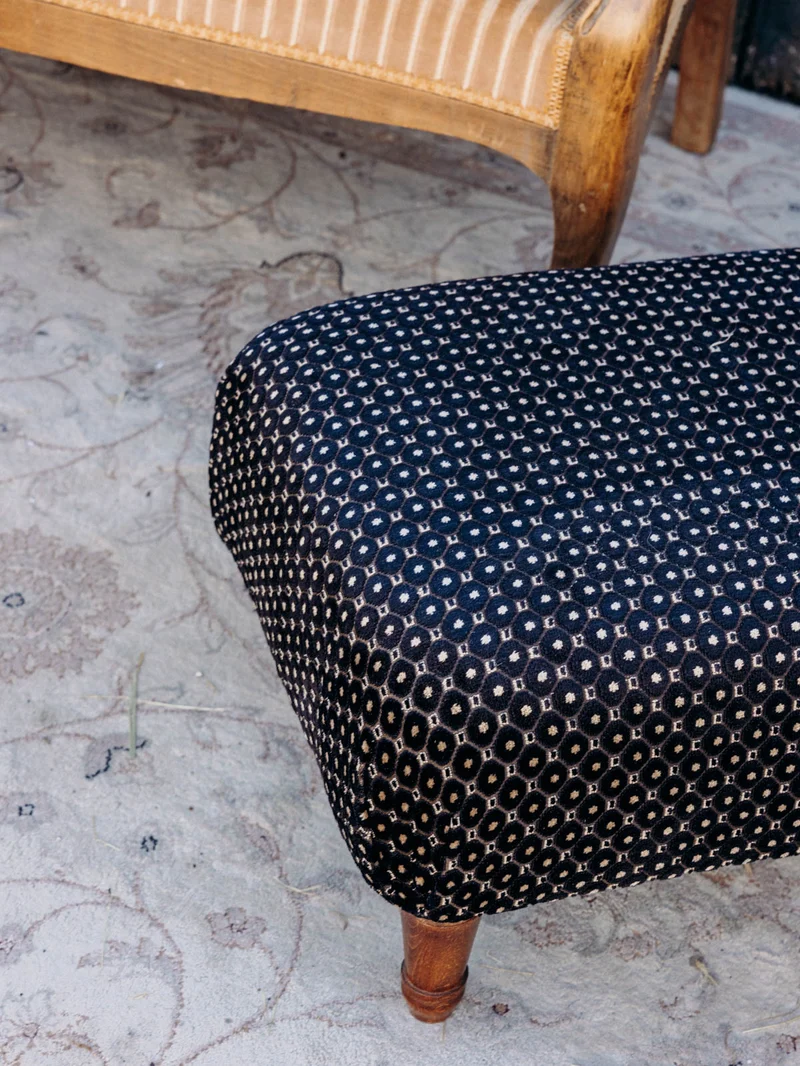 Jean-Philippe, le pouf retapissé en tissu noir à motifs N°100