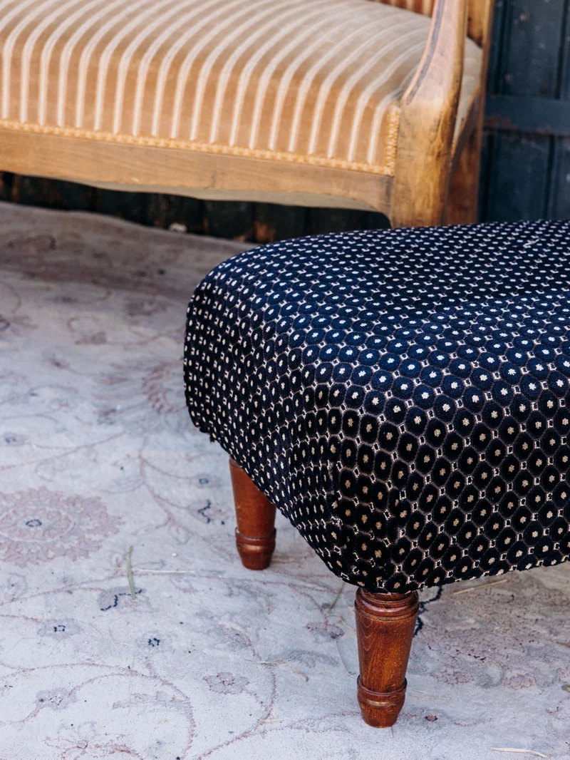 Jean-Philippe, le pouf retapissé en tissu noir à motifs N°100