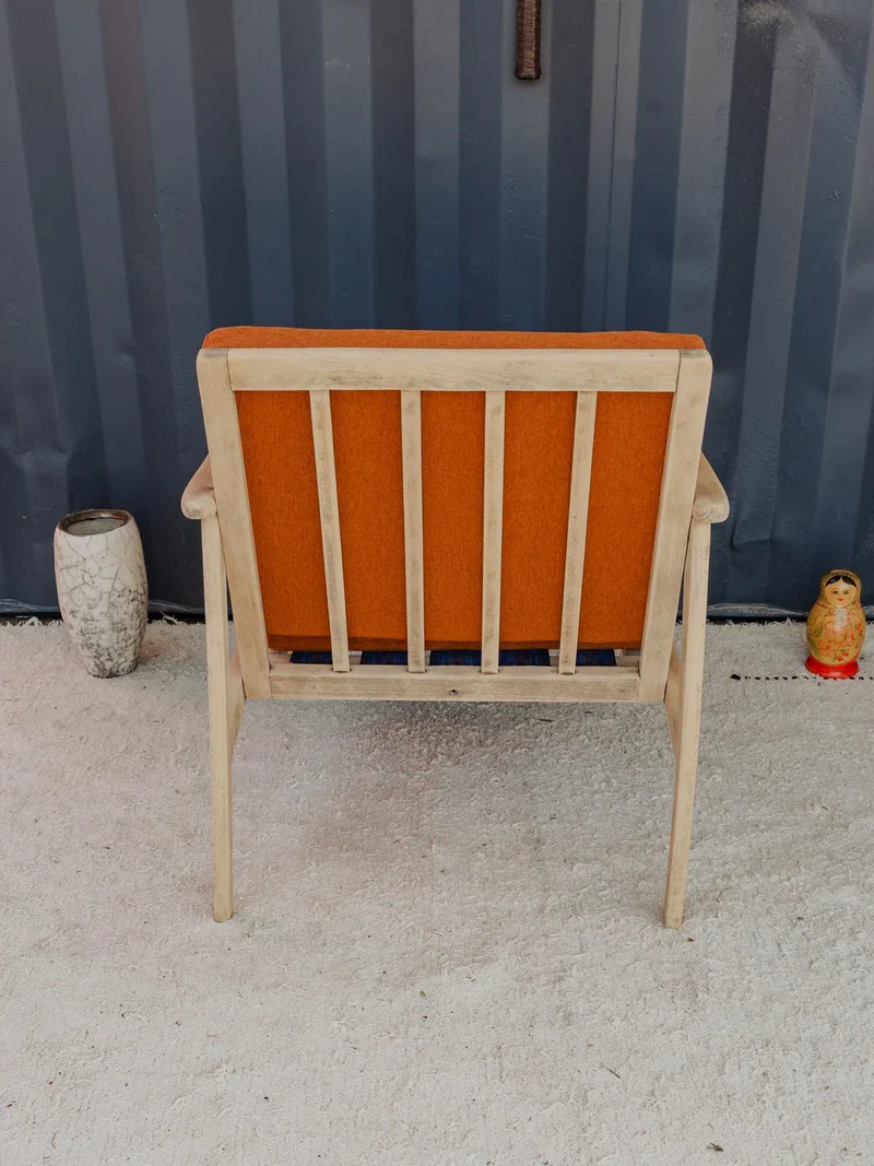 Jakob, le fauteuil en bois et coussins en tissu orange N°1181