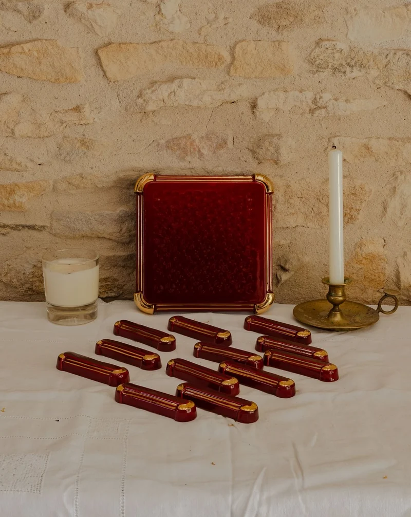 Loïs, le lot de 12 portes-couteaux et d'un dessous de plat bordeaux N°656