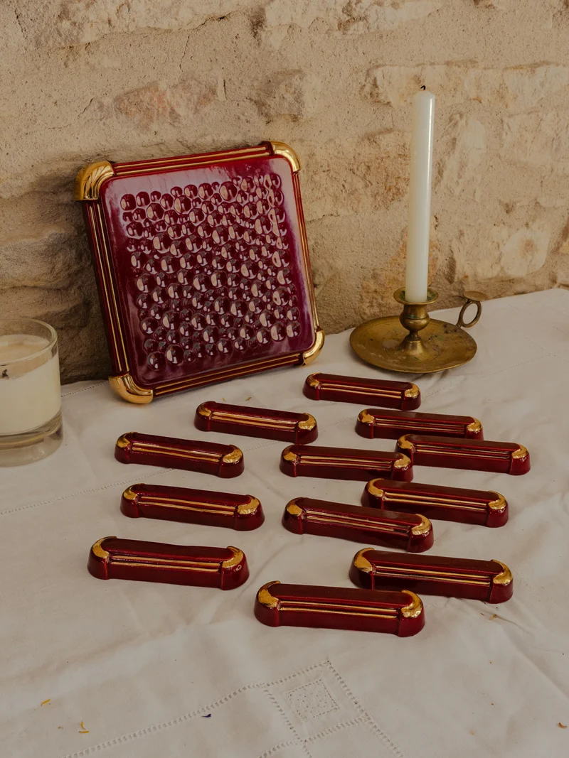 Loïs, le lot de 12 portes-couteaux et d'un dessous de plat bordeaux N°656