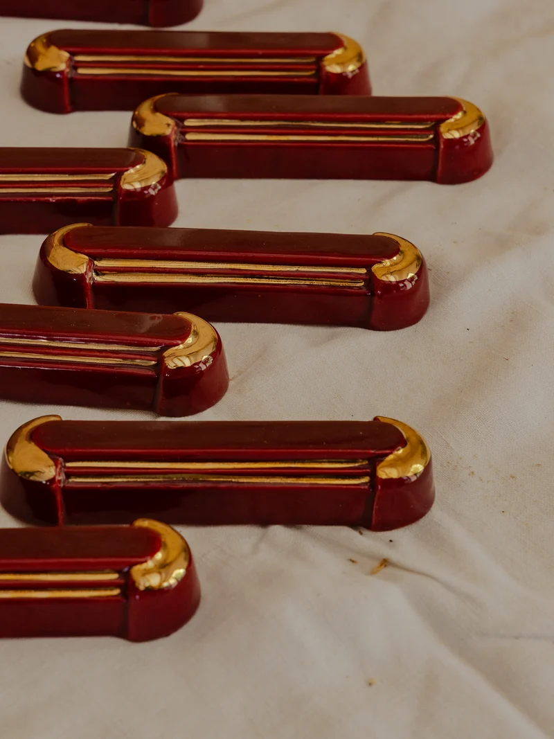 Loïs, le lot de 12 portes-couteaux et d'un dessous de plat bordeaux N°656